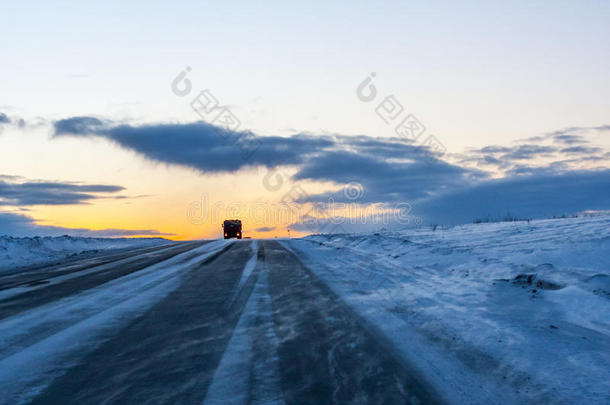 一个孤独的卡车司机在黄昏的暴风雪中开车