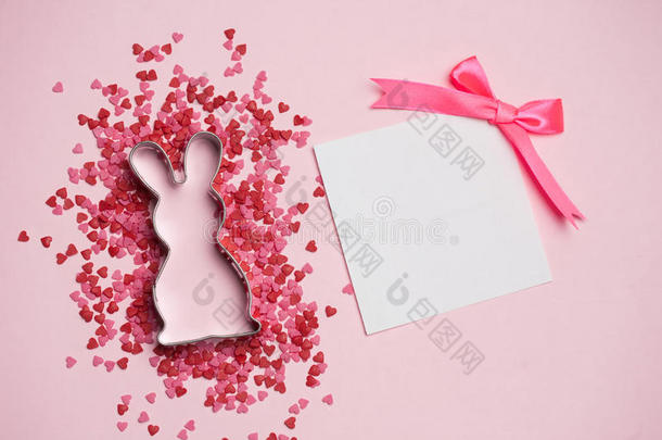 复活节明信片。 兔子和粉红色装饰在粉红色背景上的文字。