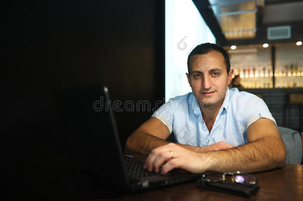 亚美尼亚英俊的男人在笔记本电脑后面工作