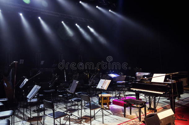 空椅子站在音乐厅的舞台上。 舞台上的钢琴。 情景交响乐音乐厅欧洲场景，交响乐m的音乐会