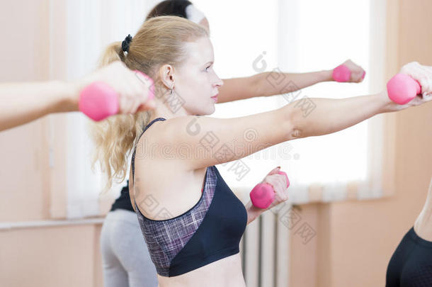 健身女孩在室内健身房用杠铃锻炼。水平图像