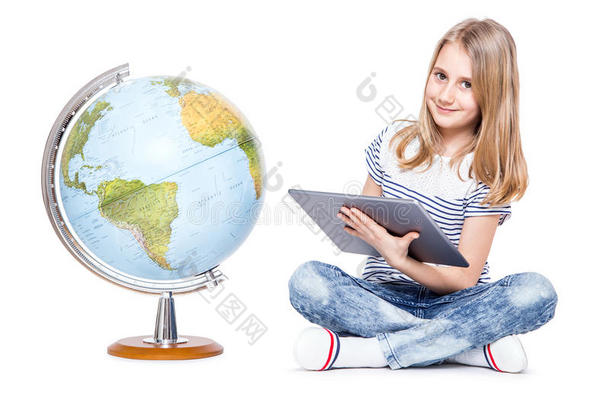 可爱的小女孩，有平板电脑和地球仪。 在地理教学中使用现代技术的女学生