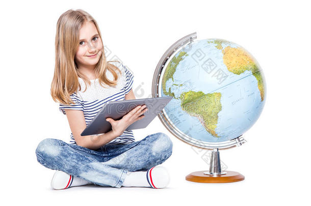 可爱的小女孩，有平板电脑和地球仪。 在地理教学中使用现代技术的女学生