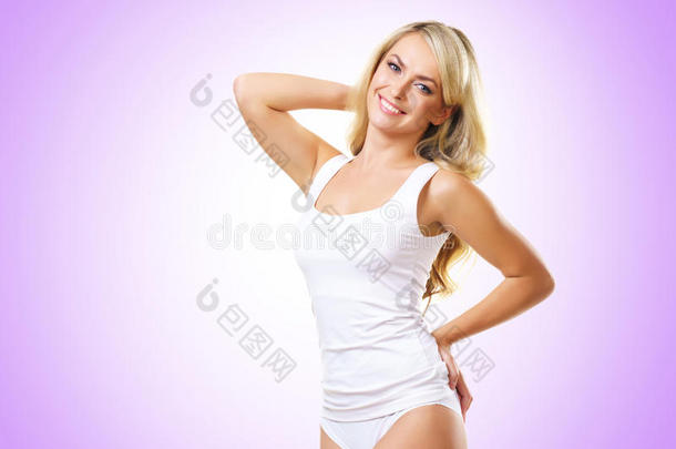 穿着白色内衣的健康活泼的女孩。 美丽健康的女人在紫罗兰的背景上摆姿势。 运动，健身，饮食，体重