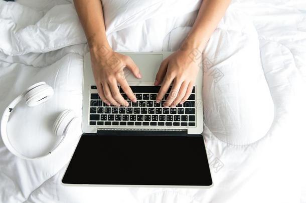 男人一次向白色的床冲浪运动互联网或w或king向便携式电脑一