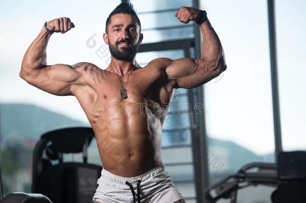 肌肉的男人挠曲肌肉采用健身房