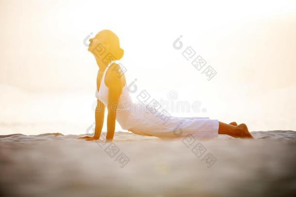 高加索人女人<strong>开业</strong>的瑜伽在海岸