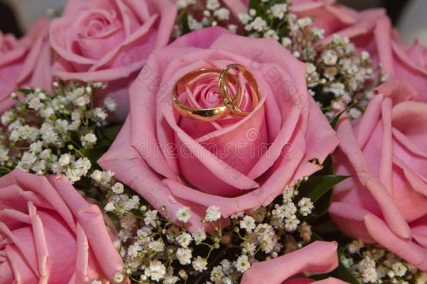 婚礼婚礼戒指和花束关于粉红色的玫瑰.