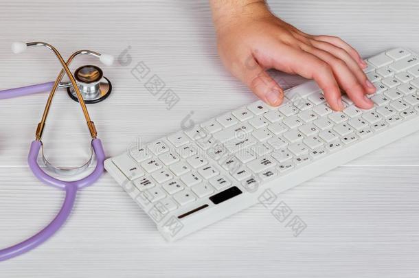 听诊器和有纸夹的笔记板和便携式电脑向书桌,医生工作的采用