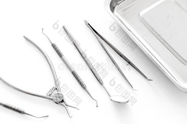 放置关于牙科医生工具在近处小玻璃管向白色的背景