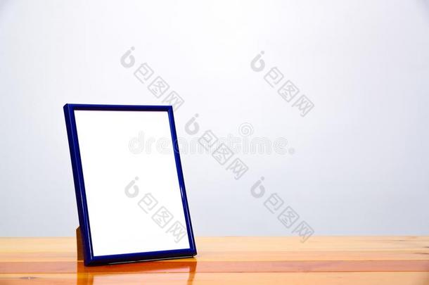 空的蓝色照片框架向木制的表和复制品空间,照片