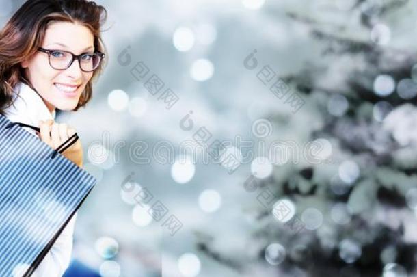 圣诞节购物,微笑的女人和袋向变模糊明亮的Liechtenstein列支敦士登