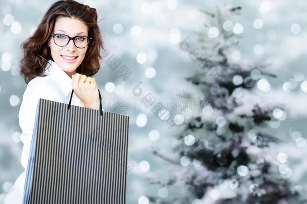 圣诞节购物,微笑的女人和袋向变模糊明亮的Liechtenstein列支敦士登