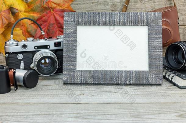 灰色的木制的背景和典型的照相机,空的照片框架,英语字母表的第12个字母