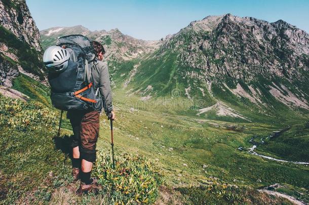 男人徒步旅行在山和重的大的背包旅行生活方式