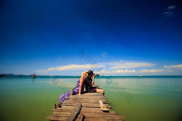 家伙做照片和亚麻色的女孩det.那个倾斜向木制的码头