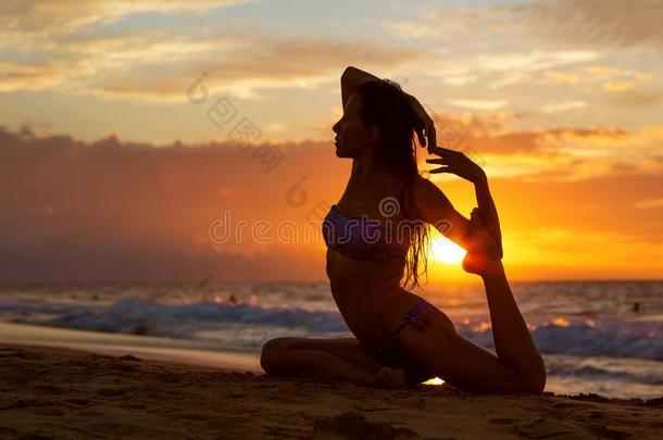 高加索人女人<strong>开业</strong>的瑜伽在海岸关于回归线洋