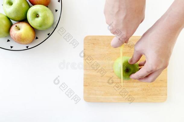 顶看法关于将切开绿色的苹果采用一半的和手在旁边塑料制品刀