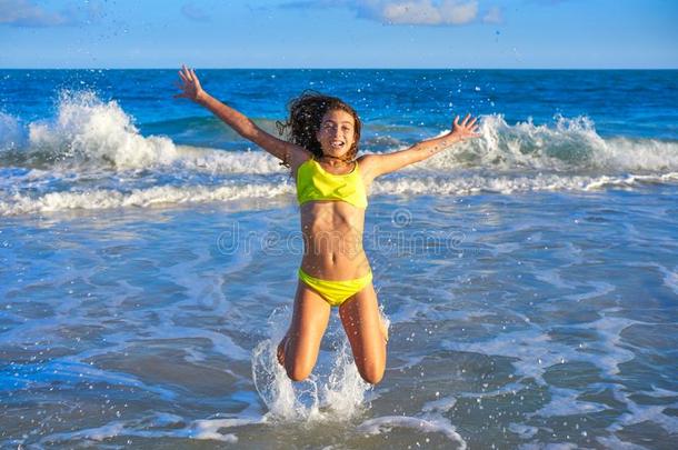 比基尼式游泳衣女孩用于跳跃的采用加勒比海日落海滩