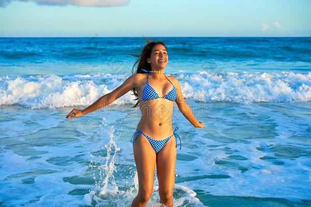 拉丁文比基尼式游泳衣女孩用于跳跃的采用加勒比海海滩