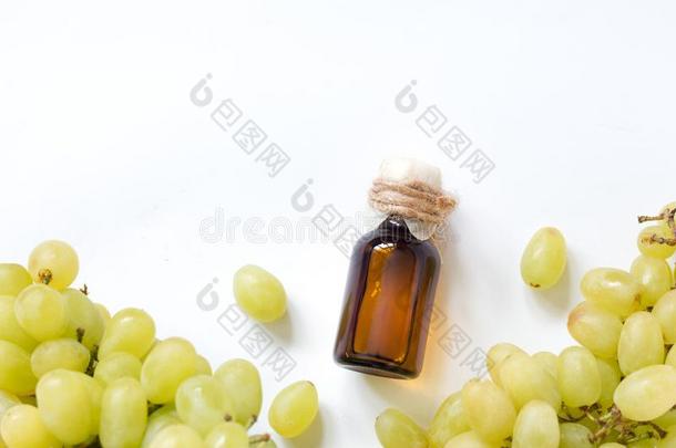 瓶子和葡萄种子基本的油向一白色的b一ckground.