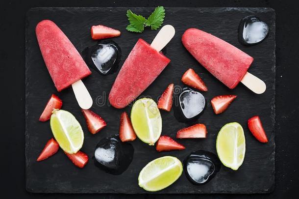 草莓和酸橙冰-乳霜或<strong>冰棍</strong>和新鲜的将切开贝里