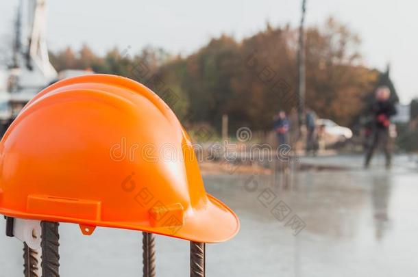 桔子安全头盔在建筑物地点和模糊的背景