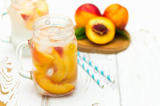 自家制的冰冷的柠檬汽水和成熟的桃.新鲜的桃子冰茶水采用