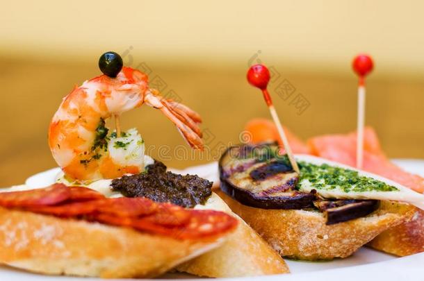 传统的西班牙的烹饪小吃.餐前小吃法国长面包夹鱼子或小鱼的烤面包和英语字母表的第3个字母
