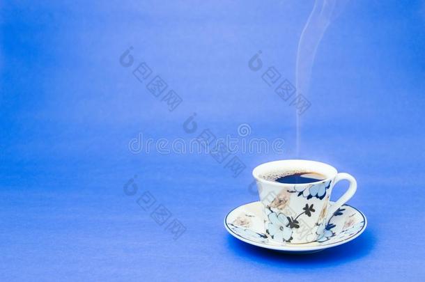 蓝色已盖章马克杯和冒热气的咖啡豆.软的烟.蓝色后台
