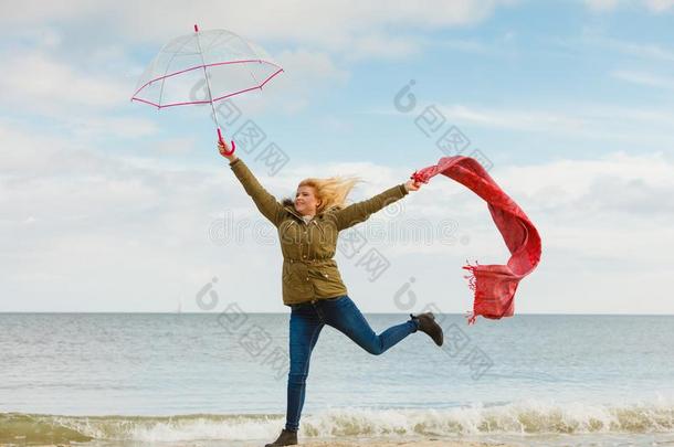 幸福的女人用于跳跃的和围巾向海滩