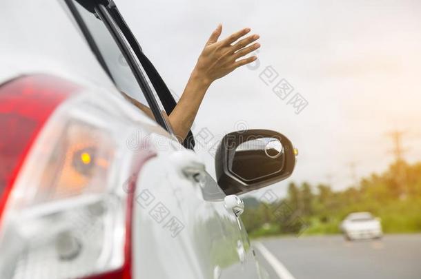 女人手在指已提到的人汽车窗向一空的国家路.