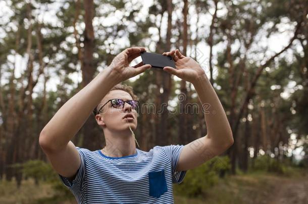 男人电话照片森林风景观念.