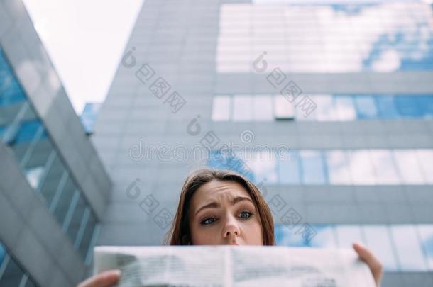 困惑的糊涂的困惑的女人阅读报纸