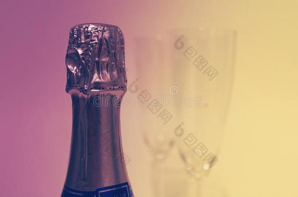 紫色的和黄色的香槟酒瓶子和两个眼镜