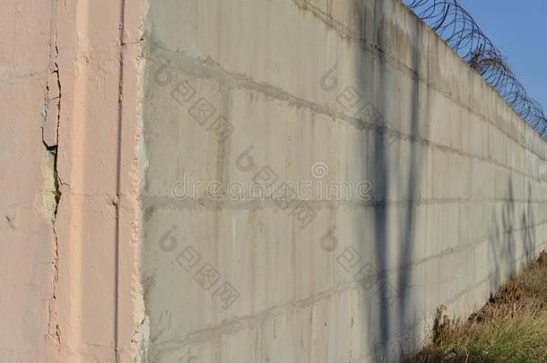 装有倒钩的金属丝伸展一起指已提到的人砖描画的墙