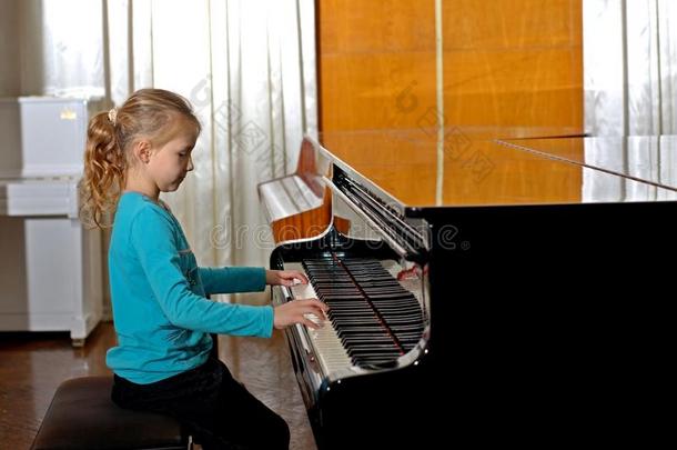 指已提到的人女孩演奏<strong>钢琴</strong>,关在上面,白色的和黑的键盘黑的