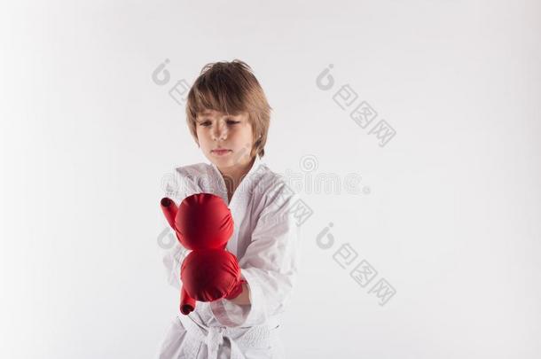 空手道小孩使人疲乏的和服和红色的拳击拳击手套