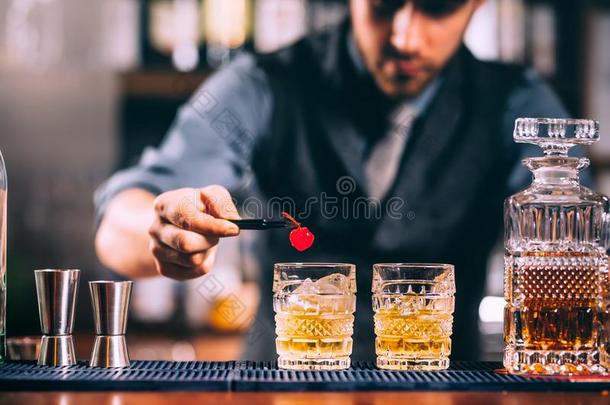 酒吧间销售酒精饮料的人手准备的老的式的威士忌酒鸡尾酒向条