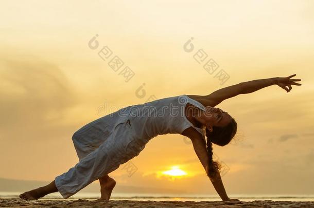 女人练习<strong>瑜伽</strong>在指已提到的人海岸在<strong>日</strong>落向BankLeumile-Israel以色列银行协会采用采用d向e