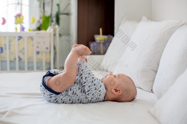 漂亮的小的新生的婴儿男孩,演奏采用床采用指已提到的人morn采用g