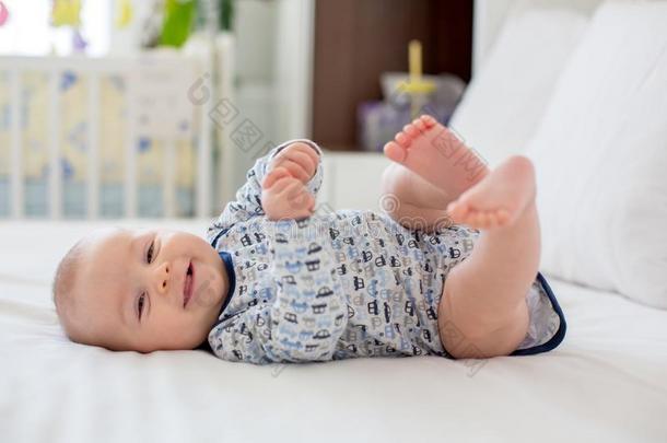 漂亮的小的新生的婴儿男孩,演奏采用床采用指已提到的人morn采用g