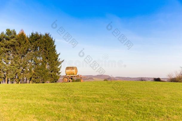 液体肥料容器停泊的向绿色的草地采用乡村