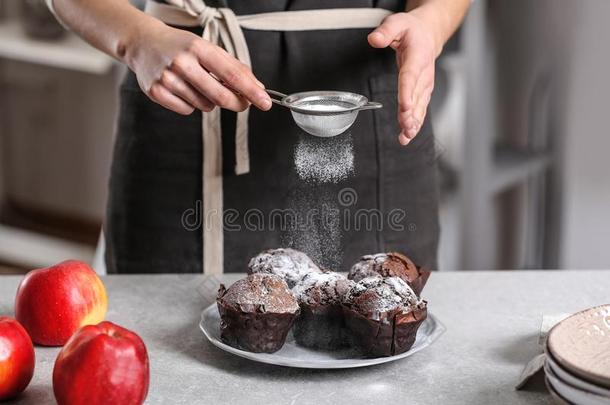 女人分型粉巧克力松饼和食糖结冰