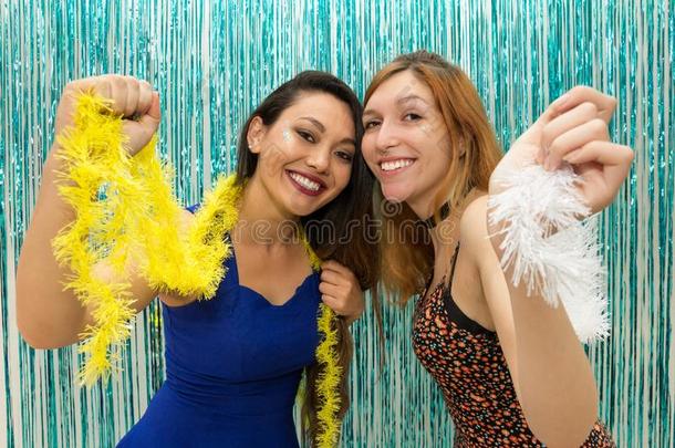 两个女朋友庆祝指已提到的人嘉年华会和穿着富有色彩的围巾