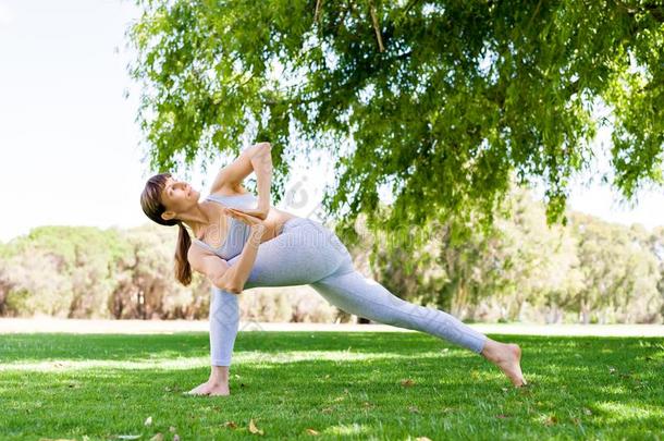 年幼的女人开业的瑜伽采用指已提到的人公园