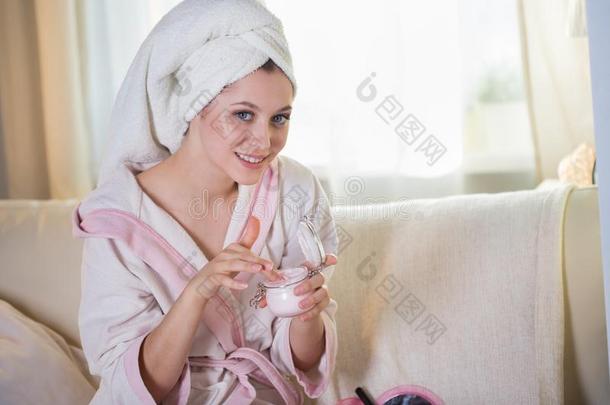 年幼的美丽的女人采用一房屋dress采用g长袍一nd和一毛巾