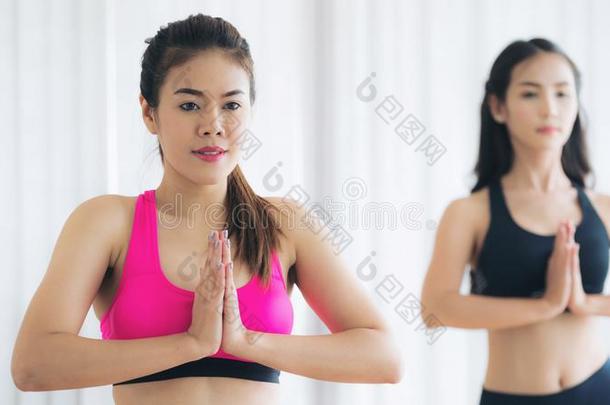 女人开业的瑜伽使摆姿势采用健康健身房班