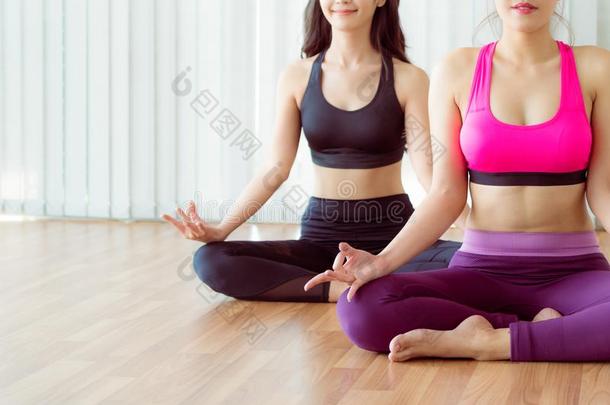 女人开业的瑜伽使摆姿势采用健康健身房班