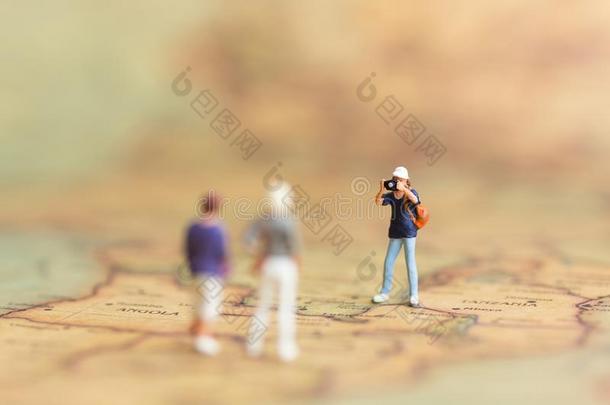 Mniature人:摄影者摄影师旅行向指已提到的人世界地图,拿photographer摄影师
